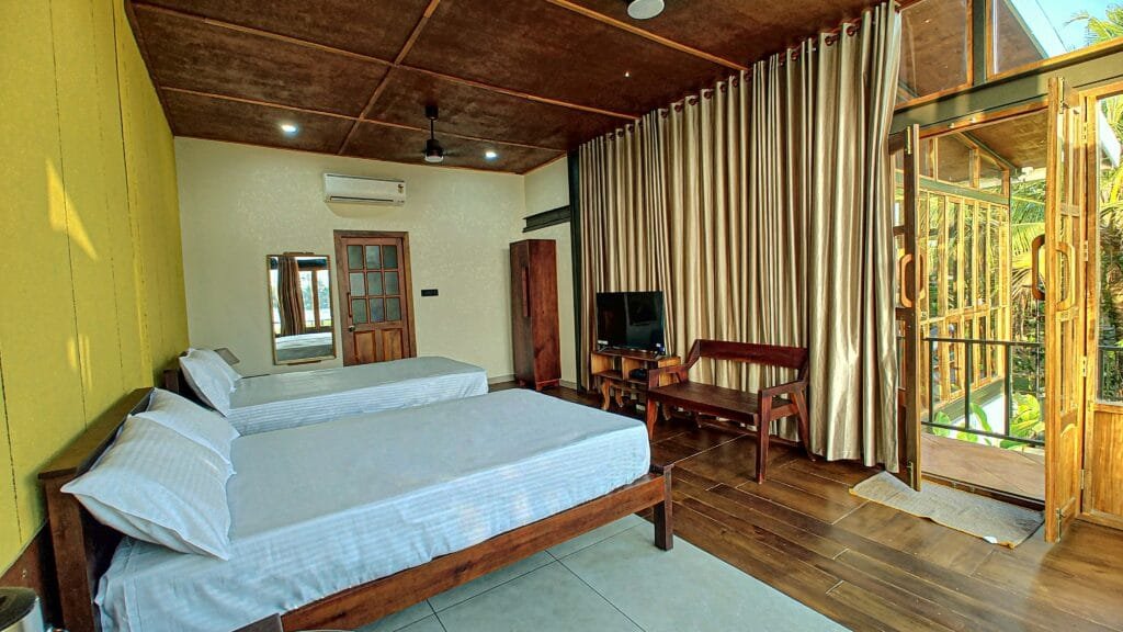 Bedroom with large windows overlooking the lake at Kyna Backwaters, Kainakary