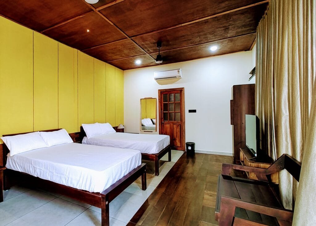 Room with twin beds and wooden ceiling at Kyna Backwaters, Alleppey